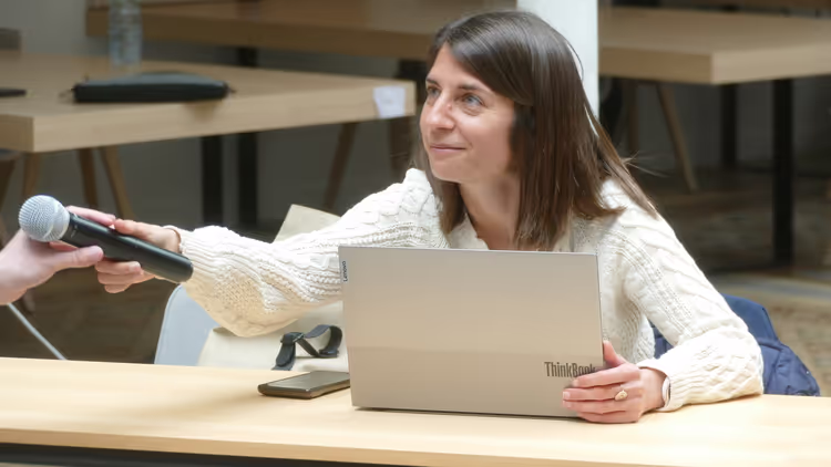 Une intervenante passe le micro à un étudiant